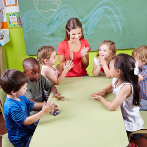 group of children and with their teacher clapping hands